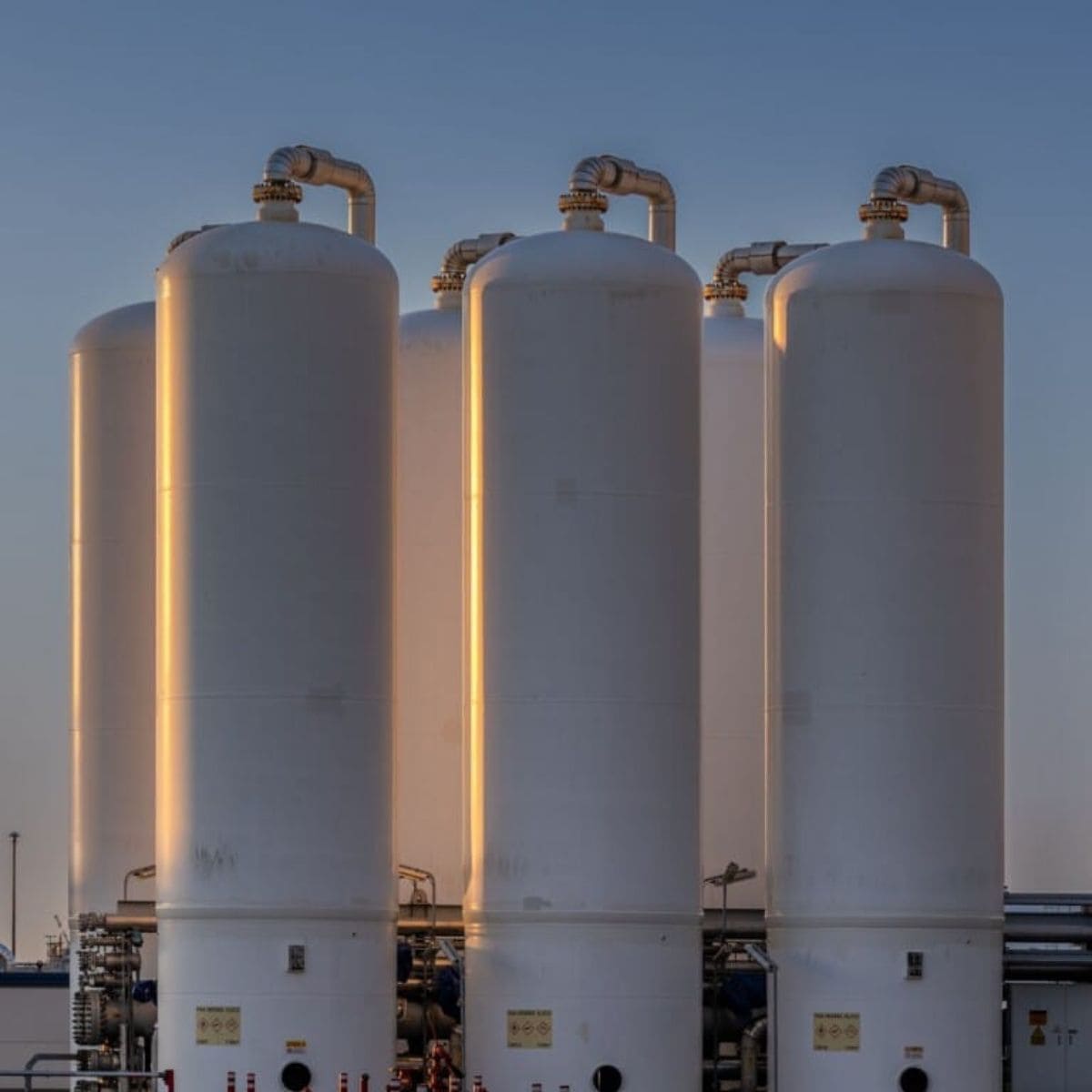 Large cryogenic storage tanks for LNG and cryogenic systems at sunset.